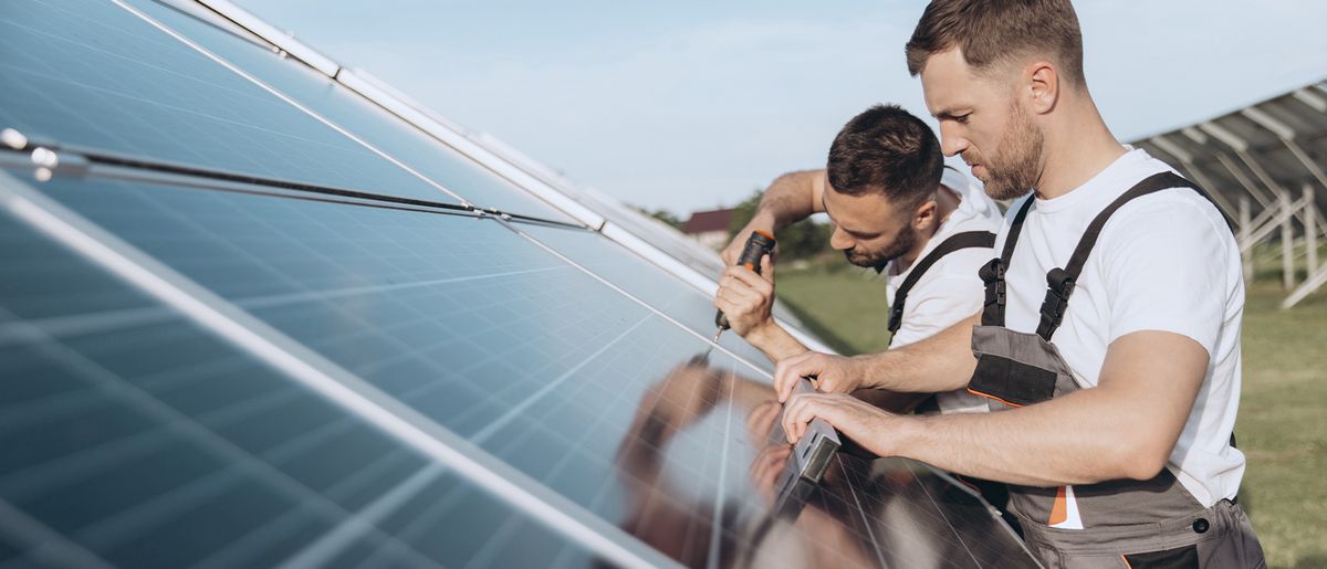 zwei freiberufliche Handwerker montieren eine Solarpanele