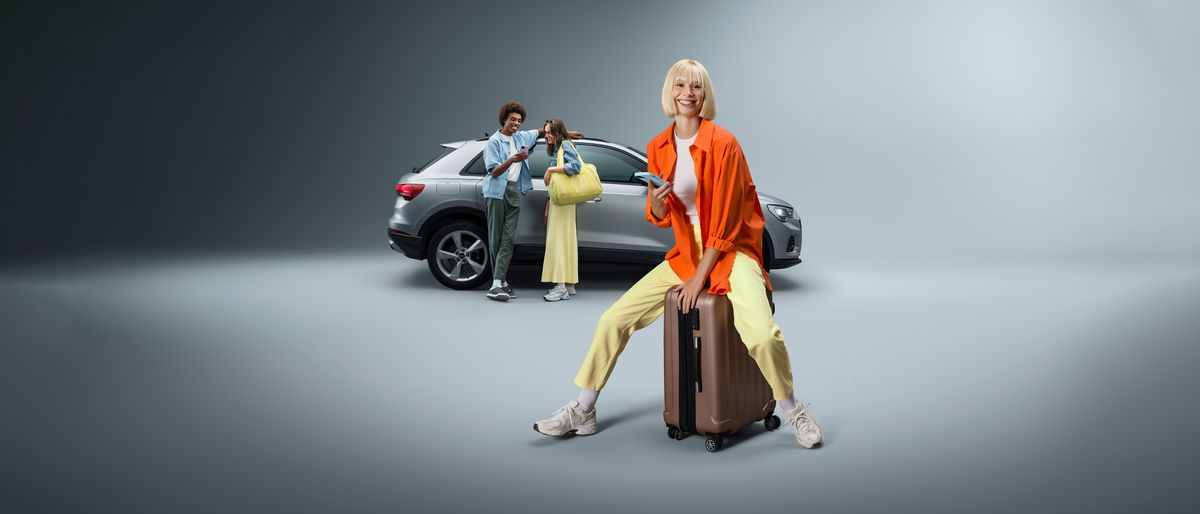 Eine Frau sitzt auf einem Rollkoffer vor einem SIXT Firmenwagen