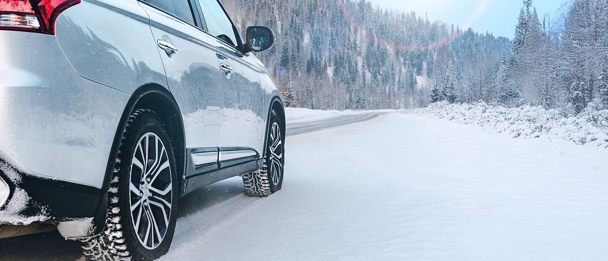 Firmenwagen mit Winterreifen auf einer Straße voll Schnee