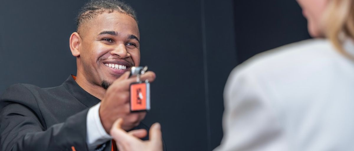 SIXT Stationsmitarbeiter überreicht SIXT Autoschlüssel an Frau