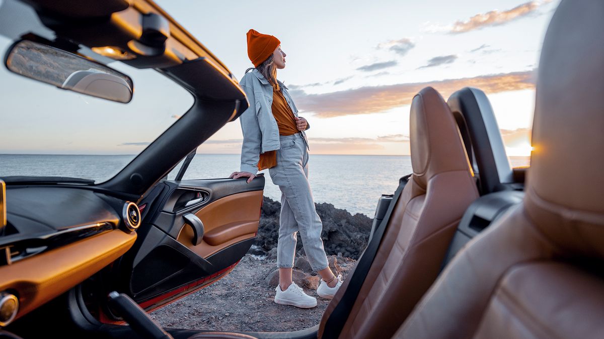 Girl Standing Next to Car on a Coast