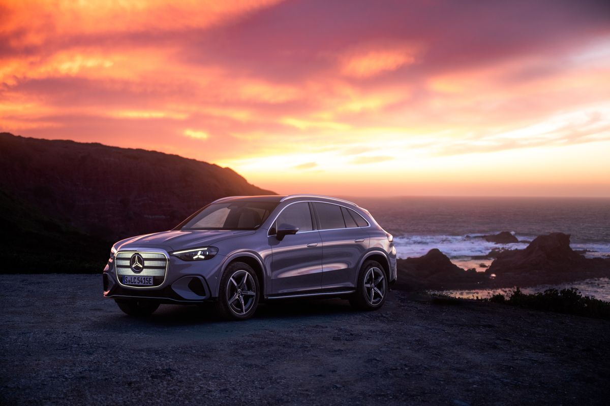Silberner Mercedes-Benz GLC vor dramatischem Sonnenuntergang an der Küste.
