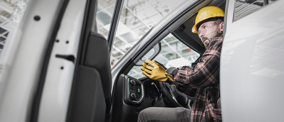 Ein Handwerker sitzt in einem Transporter