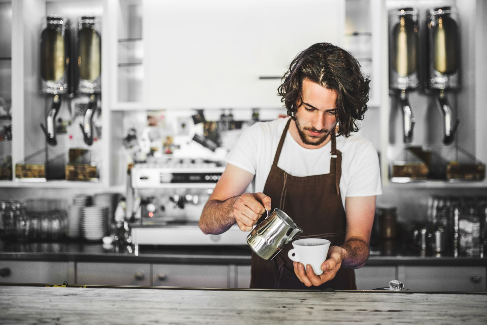 Ein Mann arbeitet als Minijobber im Kaffee und bereitet ein Getränk vor