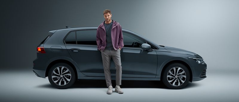 Business owner stands in front of a VW Golf