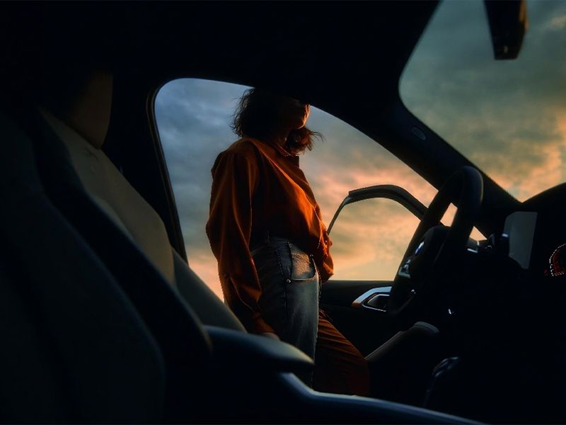 Woman standing next to a car