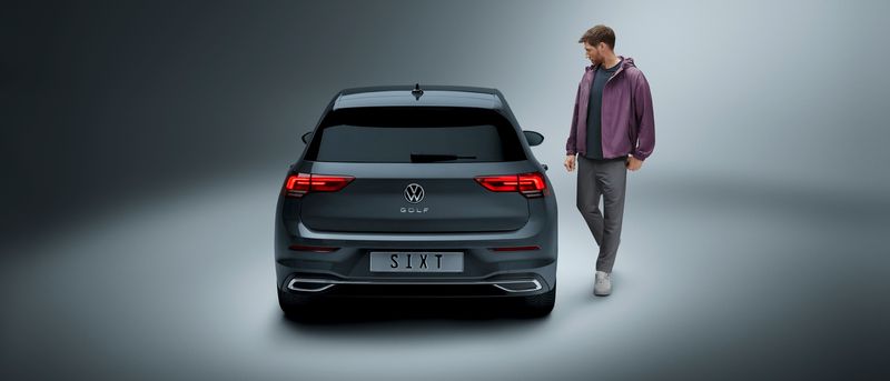 A man walks to his silver VW Golf SIXT rental car