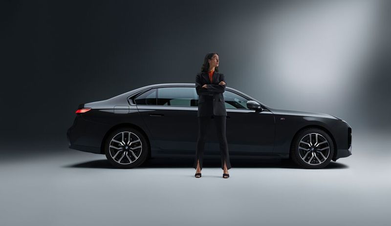 business woman standing in front of a black car