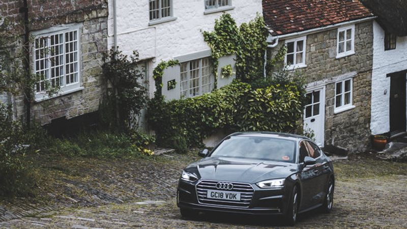 Schwarzer Audi fährt durch ein Dorf in Irland