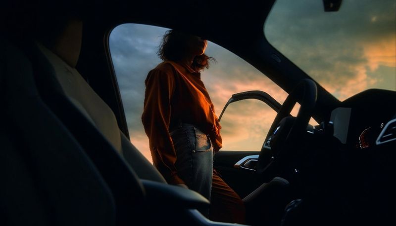 Woman standing next to a car